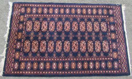 A Turkoman rug with two rows of elephant foot gul on a dark ...