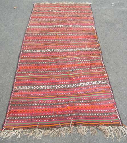 A large flat weave kilim, with multi coloured lines of patte...