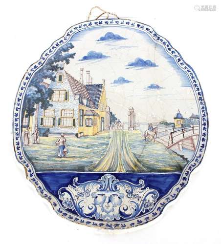 A large Dutch Delft polychrome plaque, painted with building...