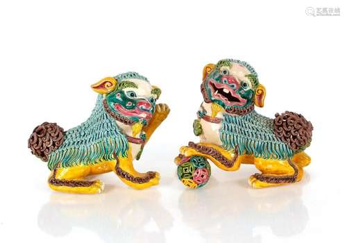 A pair of Chinese pottery Foo lions, each with mischievous e...