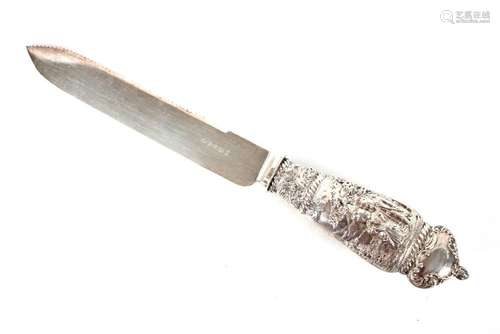 A silver handled cake knife, decorated figures and foliage