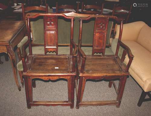 A pair of Chinese elm elbow chairs, having shaped splat back...