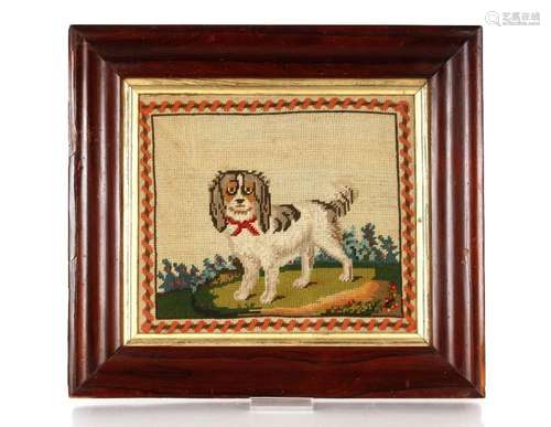 A Victorian wool work picture of a spaniel, contained in ros...