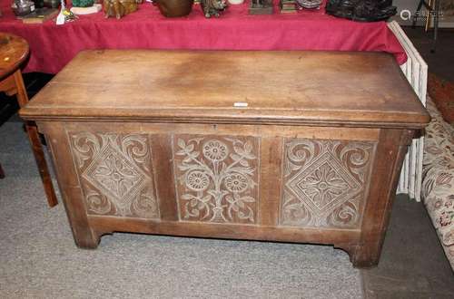 An antique carved oak coffer, with triple lozenge panelled f...