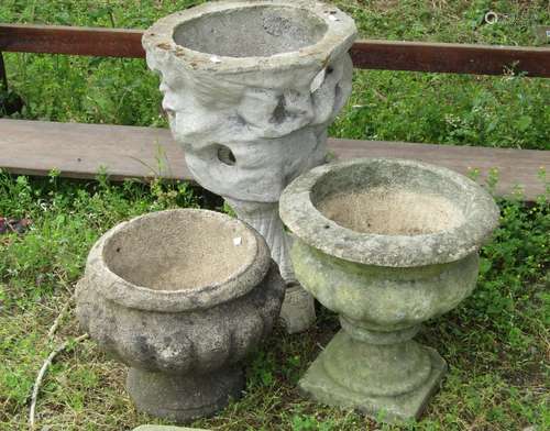 Three weathered cast composition stone garden urns of varyin...