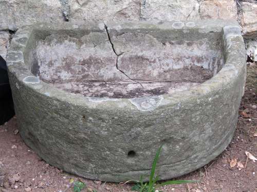 A weathered natural stone D shaped trough 61 cm wide x 48 cm...