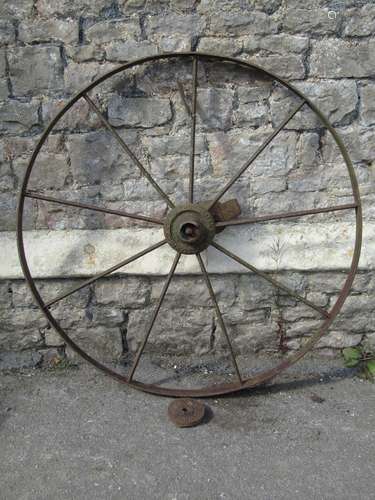 A vintage cast iron nine spoke implement wheel stamped to hu...