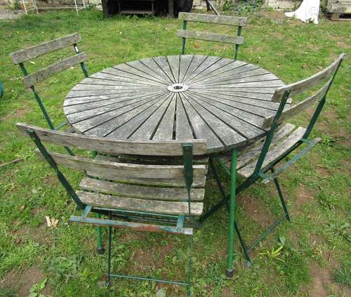 A weathered circular garden table with hardwood sunburst pat...