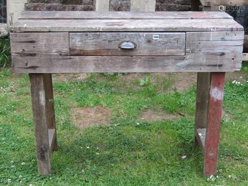 Two vintage pine work benches of varying size, one incorpora...