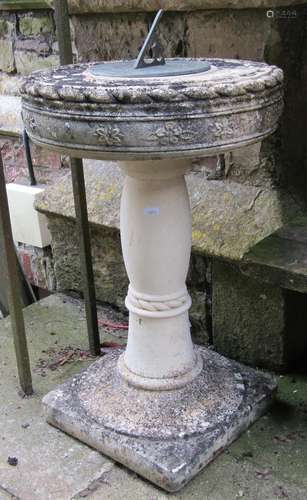 A weathered cast composition stone sundial with repeating fl...