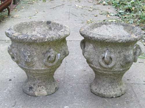 A pair of small weathered cast composition stone garden urns...