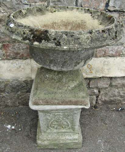 A weathered cast composition stone garden urn, the circular ...