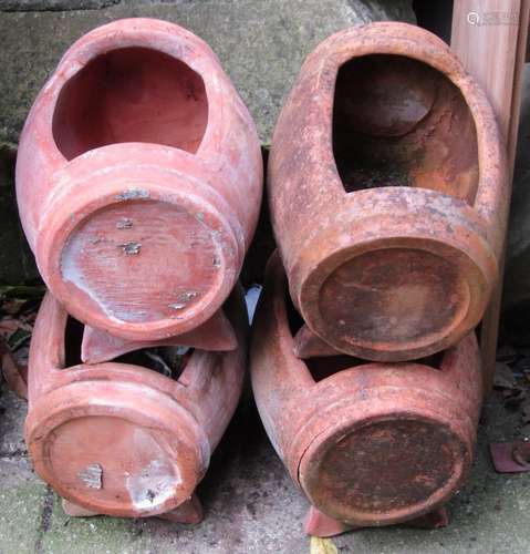 A set of four small contemporary weathered terracotta barrel...