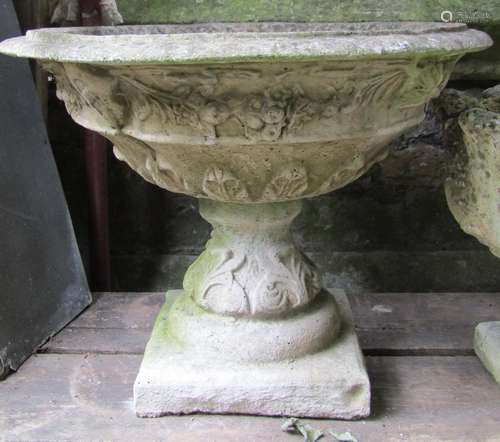 A weathered cast composition stone garden urn, the flared ci...