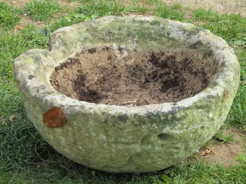 An old weathered carved/hewn natural stone circular planter/...