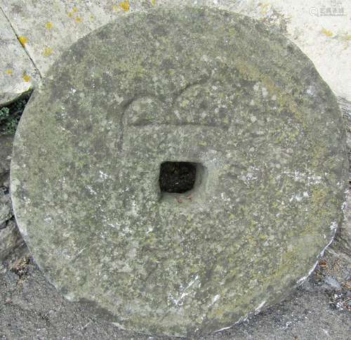 A small weathered natural stone millstone 45 cm in diameter ...