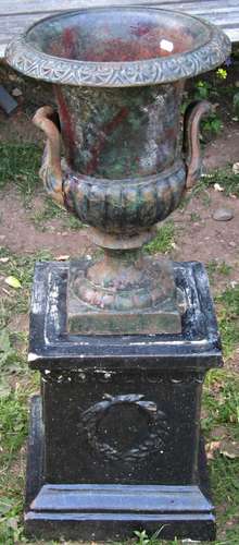 A small weathered cast iron campana shaped garden urn with f...