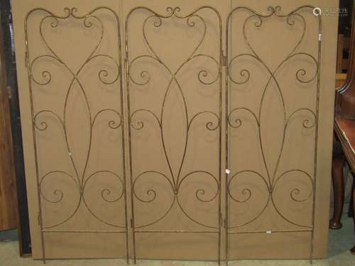 A decorative ironwork floorstanding three fold screen with o...