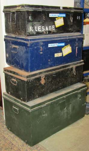 A stack of four vintage tin trunks of varying size and desig...