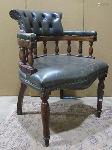 A reproduction office desk chair with green buttoned upholst...