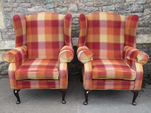 A pair of contemporary wing armchairs with shaped outline, l...