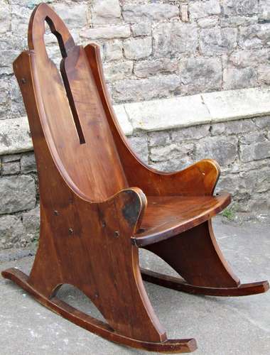 An unusual fruitwood rocking chair in the gothic manner with...