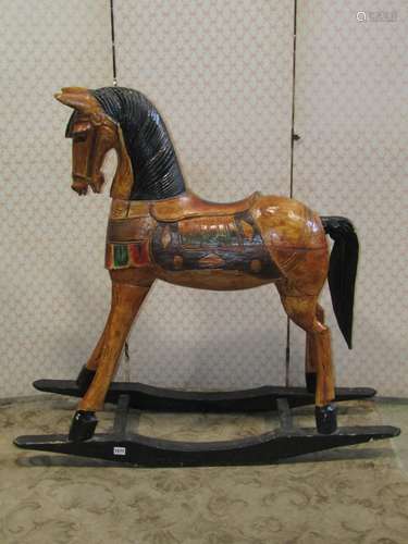 A carved wooden rocking horse with painted finish