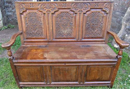 An antique old English style oak settle, the panelled box se...