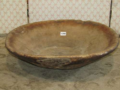 A rustic carved wooden oval tapered bowl, 56 cm x 48 cm (af)