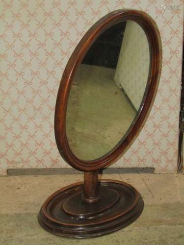 A 19th century walnut gentlemens shaving mirror of oval form...