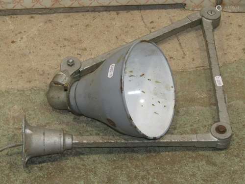 A vintage industrial articulated work lamp with conical enam...