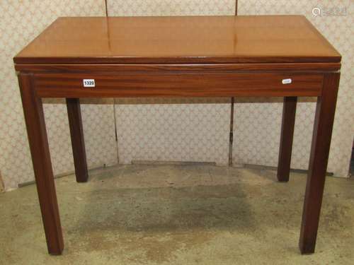 A teak foldover top card table of rectangular form raised on...