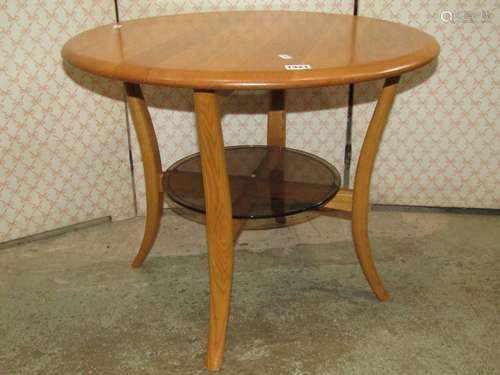 An Ercol light elm occasional table of circular form raised ...