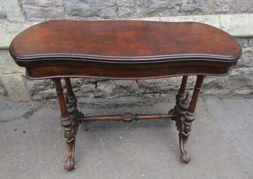 A Victorian walnut and figured walnut veneered fold over top...