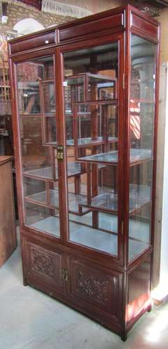 A Chinese hardwood display cabinet with plate glass to three...