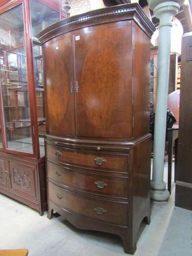 A mahogany bow fronted two sectional linen cupboard in the G...