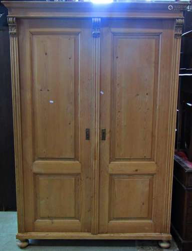 A continental stripped pine knockdown wardrobe enclosed by a...