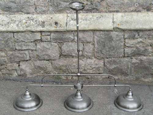 A contemporary cast metal hanging ceiling light with three d...