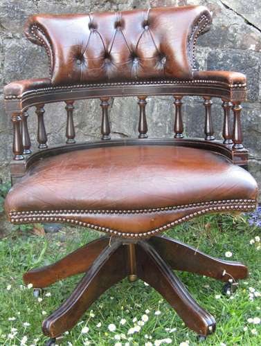 A reproduction swivel office/captains type chair, with brown...