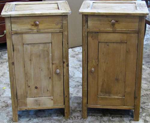 A pair of stripped pine bedside cupboards each enclosed by a...