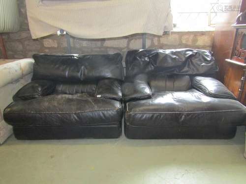 A pair of low substantial easy chairs with soft black leathe...