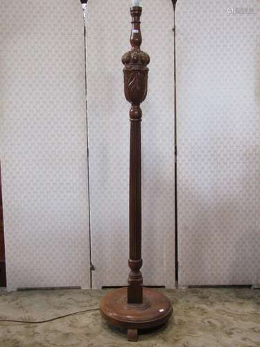 An oak standard lamp with carved and moulded baluster cup an...