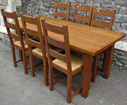 A contemporary oak kitchen table, the heavy plank top raised...