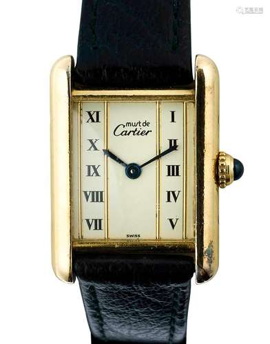 CARTIER<br />
Must de. Montre de dame “Tank” en vermeil. Cad...