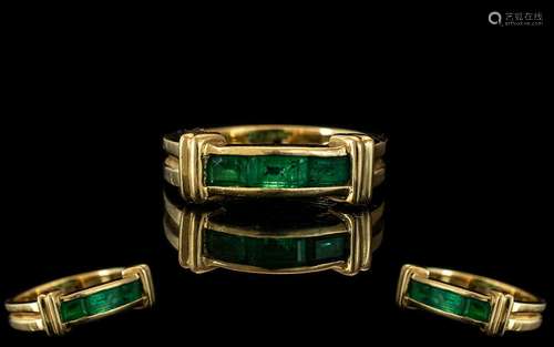 An 18ct Gold Emerald Ring Three channel set baguette emerald...