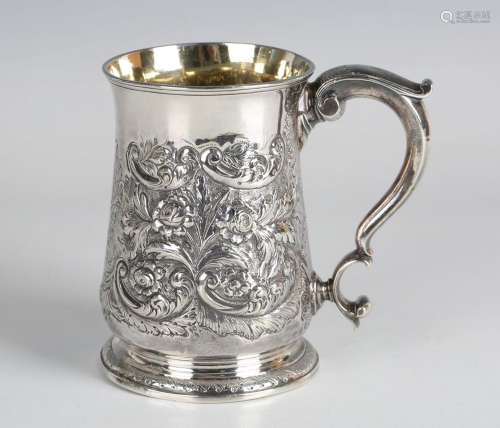 A George II silver tankard with scroll handle, the baluster ...