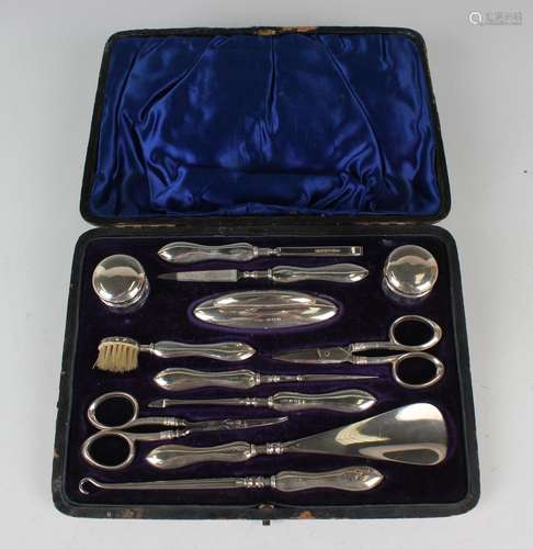 An Edwardian silver mounted twelve-piece dressing table set,...