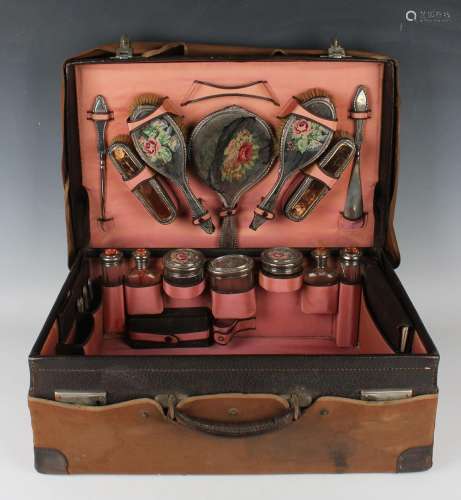 A George V leather travelling vanity case, the interior fitt...
