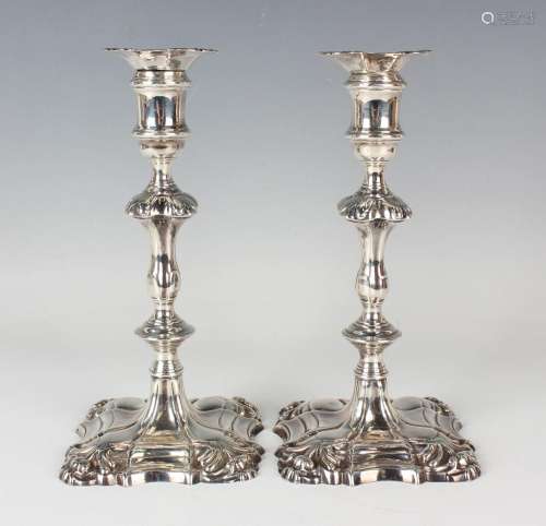 A pair of George II cast silver candlesticks, each with a de...