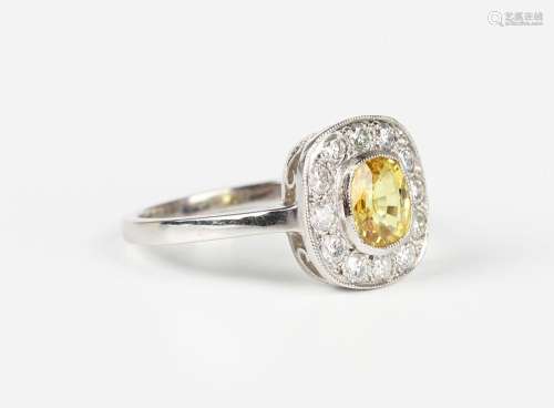 A platinum, yellow sapphire and diamond cluster ring, collet...